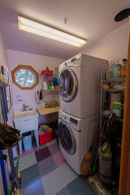 The laundry room has stacked washer and dryer in this furnished Bend executive rental.