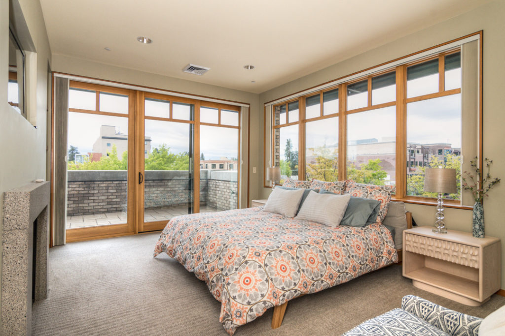 Primary bedroom with floor to ceiling windows in downtown Bend executive rental