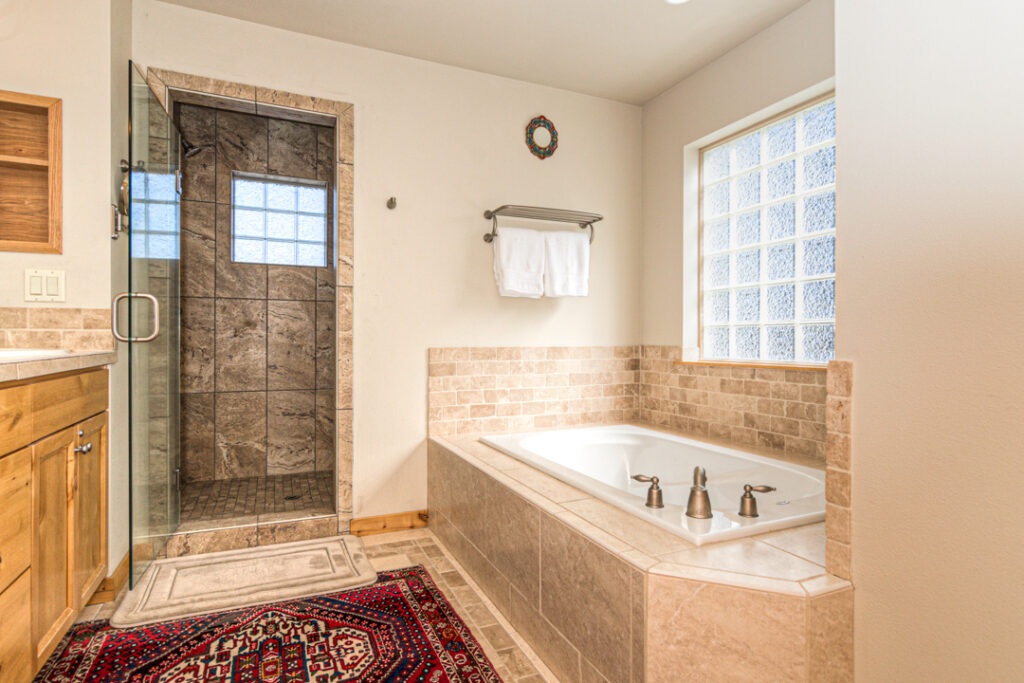 The primary bathroom of this Bend Oregon executive rental includes a soaking tub and walk in shower