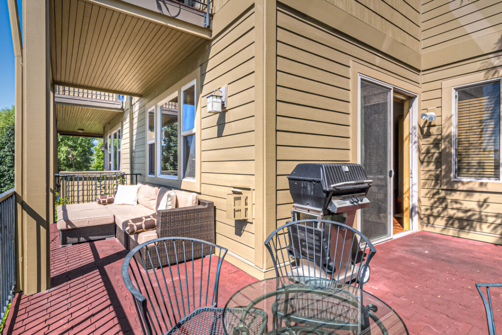 This second level deck has a couch, dining table and BBQ in this Old Mill river rental