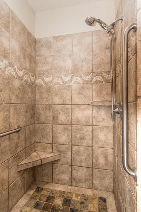 A tiled walk in shower in the primary bathroom There are hardwood floors throughout the living spaces of this rental in the Sagewood neighborhood of SW Bend