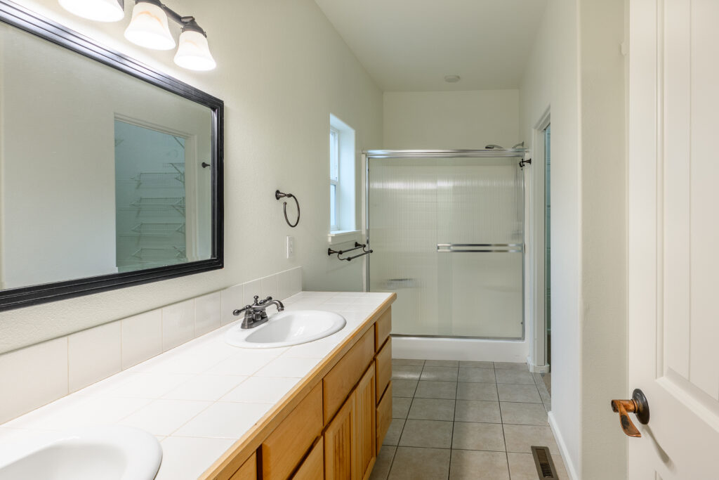 The primary bathroom of this Redmond rental has tiled floors and a walk in shower.