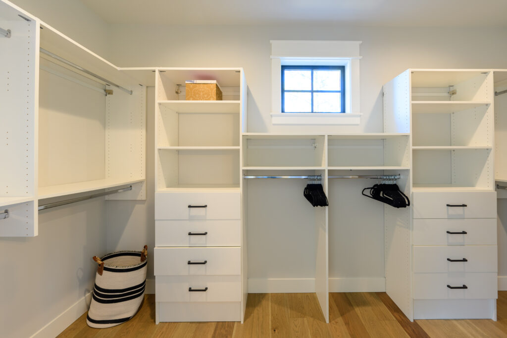 The primary bedroom walk in closet of this executive rental includes built in drawers and shelves in addition to plenty of space for hanging your clothes.