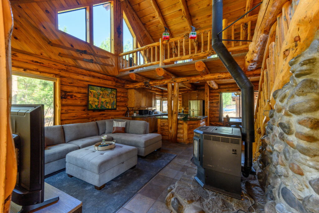 The living room of this furnished log home rental in Bend has a pellet stove.