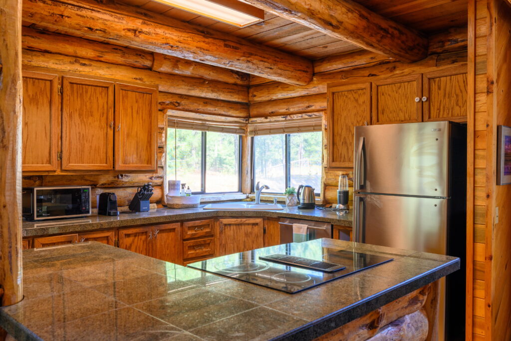 Stainless steel appliances and tile granite counter tops add a modern accent to this log home.