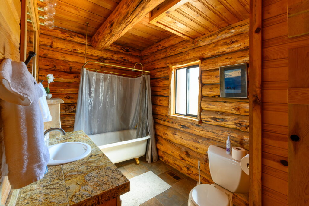 The primary bathroom this furnished log home rental in Bend includes a clawfoot tub.