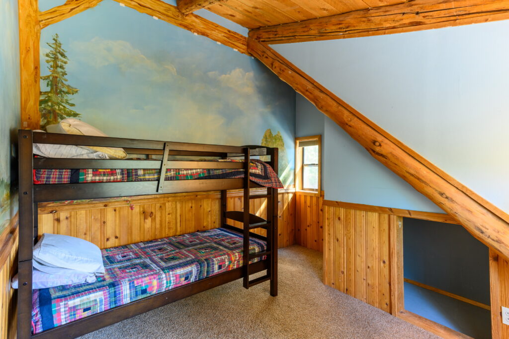 One of the upstairs bedrooms of this furnished log home rental in Bend has a twin bunk bed